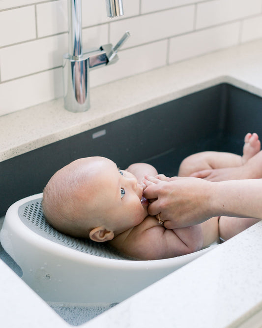 baby lying in bath tub